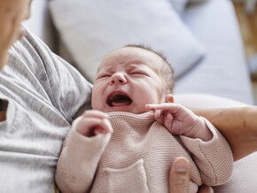 Новонароджене немовля плаче на руках Новонароджене немовля плаче на руках