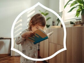 Малюк читає книжку в затишній кімнаті з рослинами.