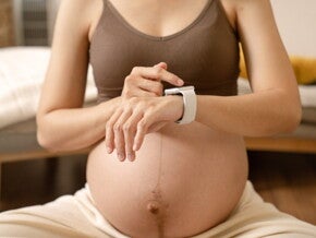 Беременная женщина проверяет показатели на смарт-часах