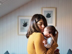 Мама ніжно обіймає новонародженого вдома