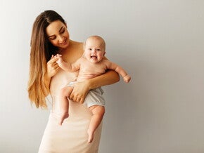 Мама тримає усміхненого немовля на руках