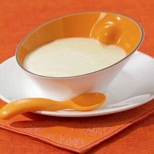 Молочна каша в дитячій мисці з ложкою