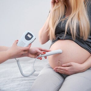 Врач слушает сердцебиение ребёнка в животе беременной женщины