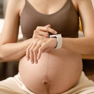 Вагітна жінка перевіряє показники на смартгодиннику