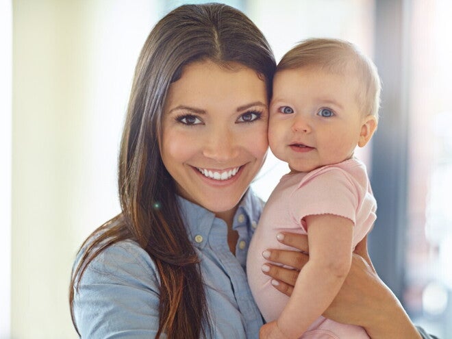 Жінка тримає на руках немовля