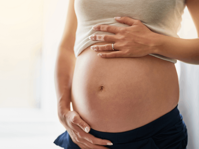 Вагітна жінка тримає живіт